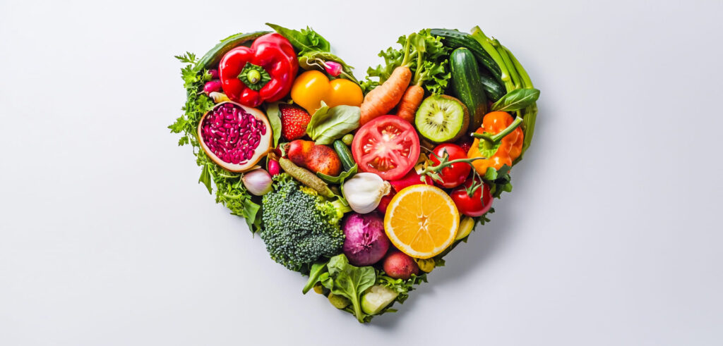 Une variété de fruits et légumes colorés disposés en forme de cœur, symbolisant une alimentation saine et équilibrée.
