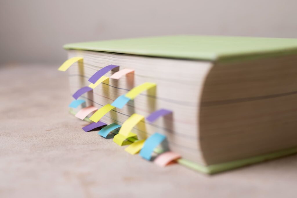 Un gros livre marqué de nombreux onglets colorés pour une organisation précise et visuelle des informations.